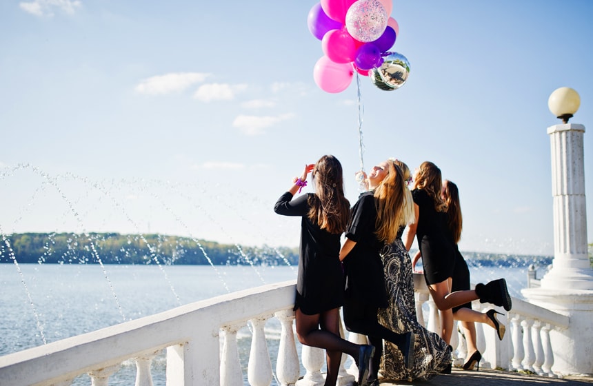 Frauen stehen zusammen auf einer Brücke und feiern einen Junggesellenabschied