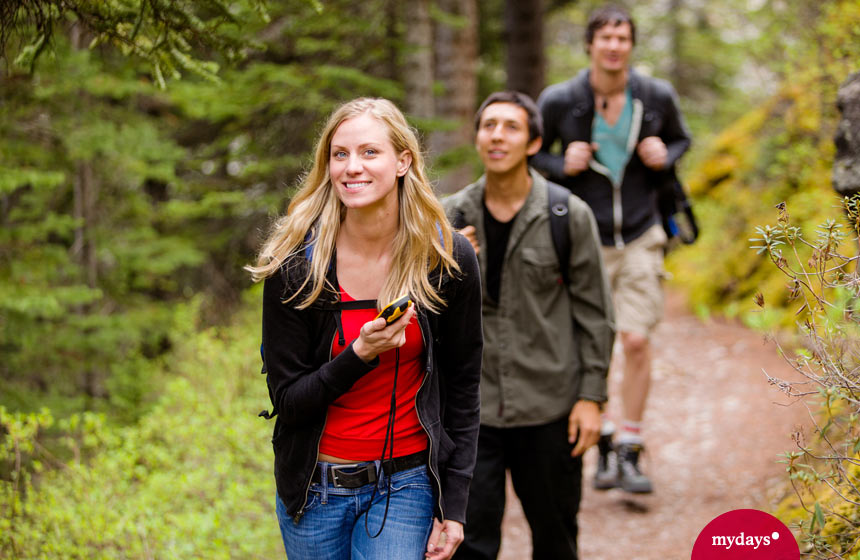 Unternehmungen mit Freunden: Eine Gruppe wandert im Wald beim Geocaching mit GPS Gerät.