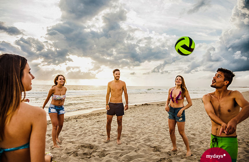 Die schönsten Unternehmungen mit Freunden: am Strand gemeinsam Volleyball spielen im Sommer.