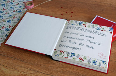 Erinnerungsbuch auf Holztisch Blumenpapier