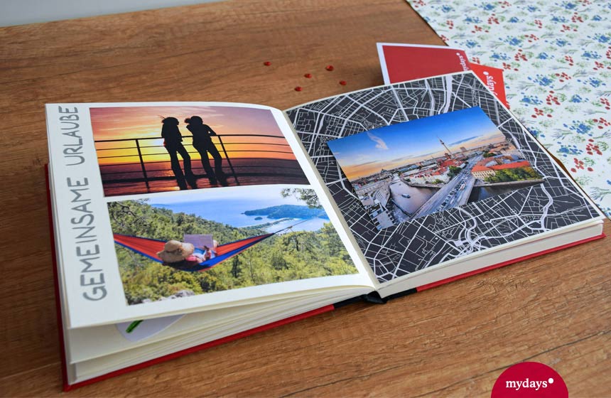 Erinnerungsbuch auf Holztisch Urlaubsfotos