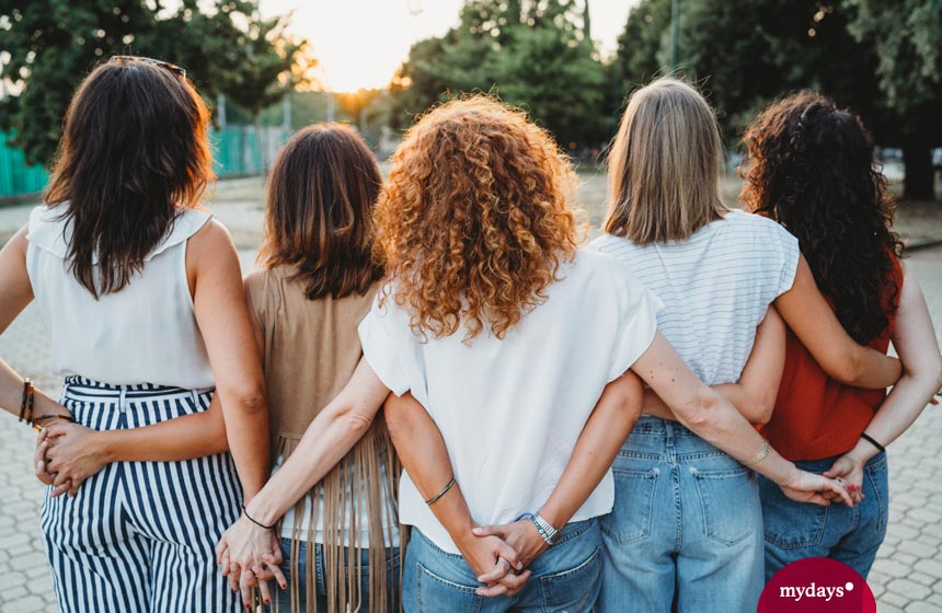 5 Frauen in der Rückenansicht umarmen sich