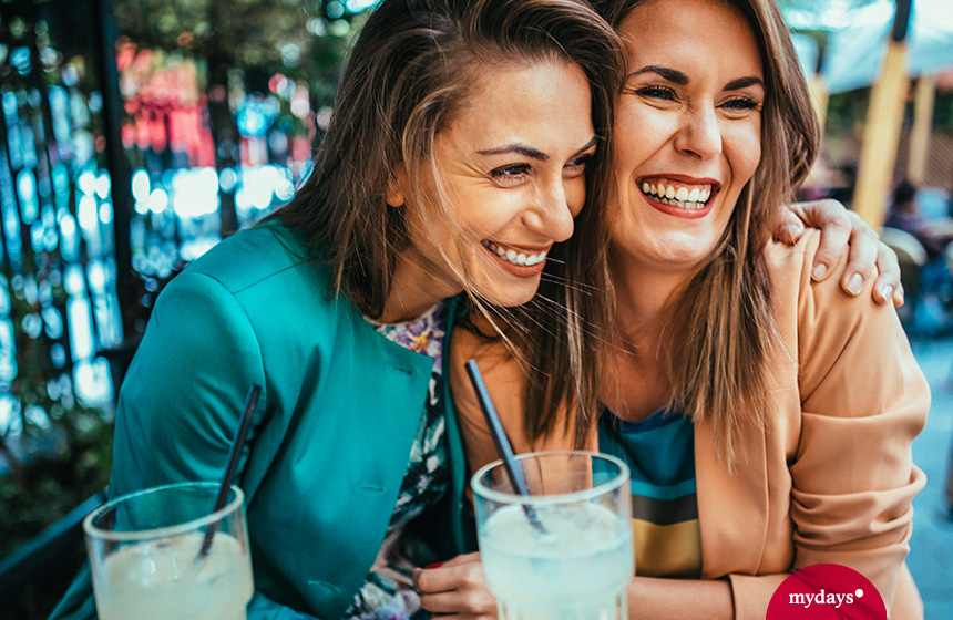 Frauen lachen und trinken Cocktails